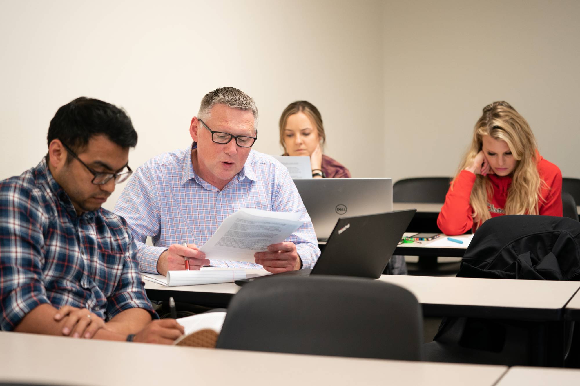 Small group of Continuing Education students review class notes - Commitments to our Community